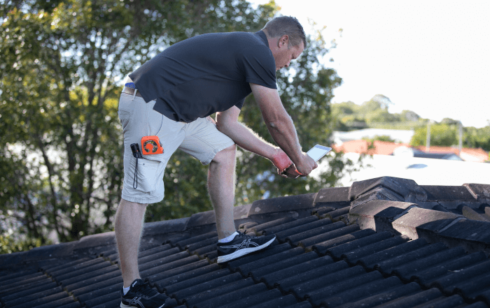 Summer storms roof inspection Building inspector checks roof for damage during summer storms